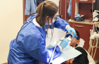 Student provides oral health screening at Back to School Brush-Up™