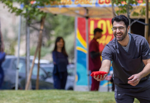 Student playing bean bag toss at a university event