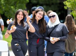 Three students pose for photo at a university event