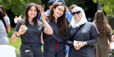 Three students pose for photo at a university event